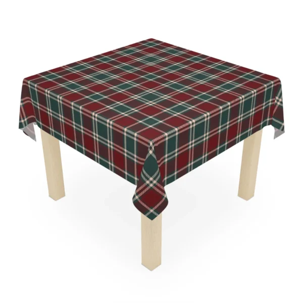 Square wooden table wearing a burgundy tartan Christmas tablecloth with corners hanging down