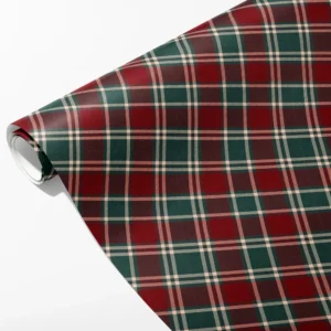 Roll of burgundy and green tartan Christmas wrapping paper with fine white lines, partly unrolled on white