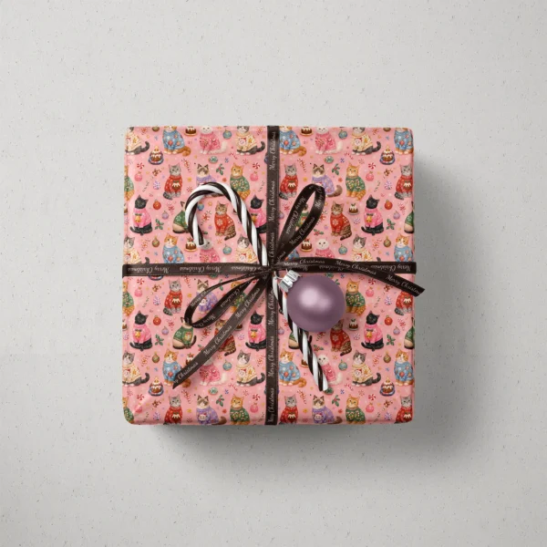 Top view of a gift in Christmas cat paper with a ribbon, candy canes and a bauble