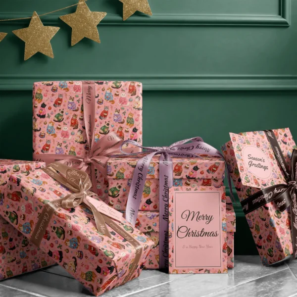 Stack of presents in Christmas cat paper with ribbons and a Merry Christmas card by a green wall