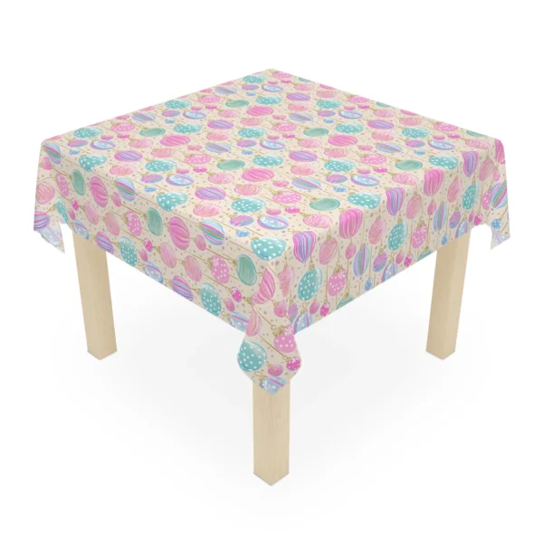 Square wooden table covered with a cream Christmas tablecloth of pastel glass-style ornaments