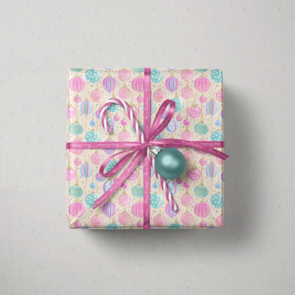 Top view of a gift in cream pastel ornament paper with a ribbon, candy canes and a bauble