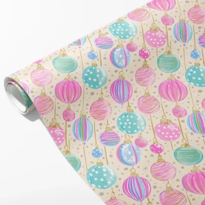 Roll of cream wrapping paper with pastel pink, teal and lilac Christmas ornaments, partly unrolled on white