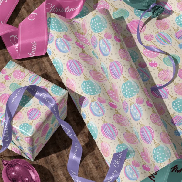 Rolls of cream pastel ornament gift wrap and a wrapped box with satin ribbons on a wooden floor