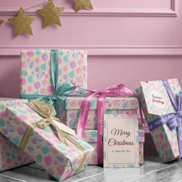 Stack of presents in cream pastel ornament paper with ribbons and a Merry Christmas card by a pink wall