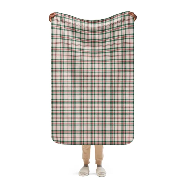 Narrow lap-size plaid sherpa throw in cream, green and red, held up by both top corners