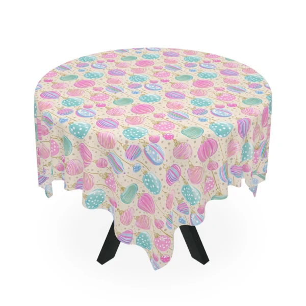Round table under a cream tablecloth scattered with pink, mint and blue hanging baubles