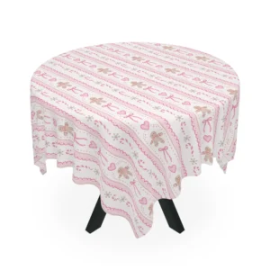 Round table draped in a cream tablecloth printed with pink gingerbread cookies, bows, hearts and candy canes