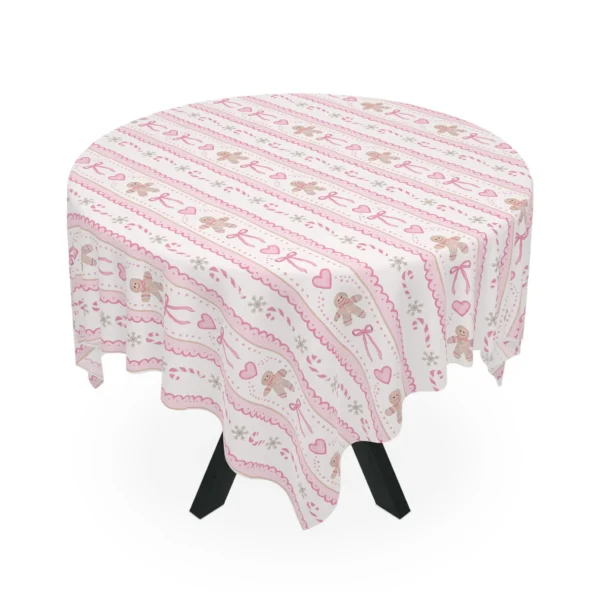 Round table draped in a cream tablecloth printed with pink gingerbread cookies, bows, hearts and candy canes