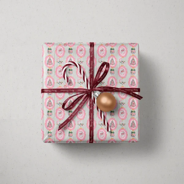 Top view of a gift in pink Santa sage stripe paper with a ribbon, candy canes and a bauble