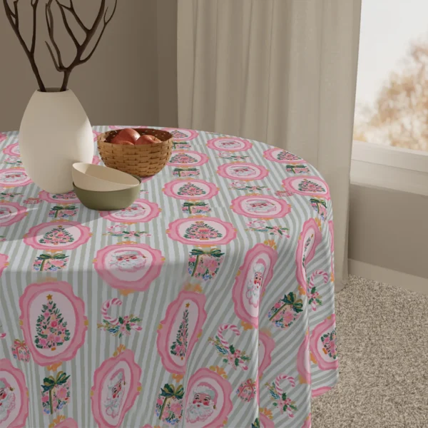 Close-up of pink framed Santas and wrapped gifts on sage stripes near a vase and a basket of apples