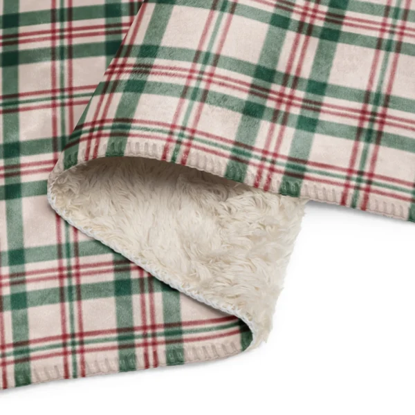 Close-up of the plaid blanket's stitched edge folded back over the soft sherpa underside
