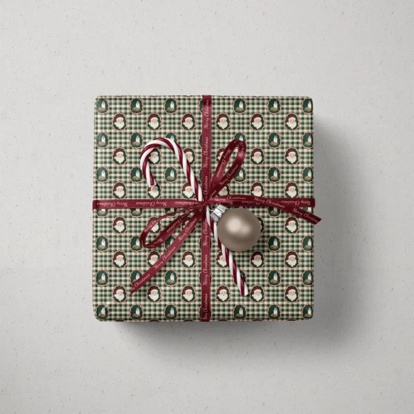 Top view of a gift in Santa milk and cookies gingham paper with a ribbon, candy canes and a bauble