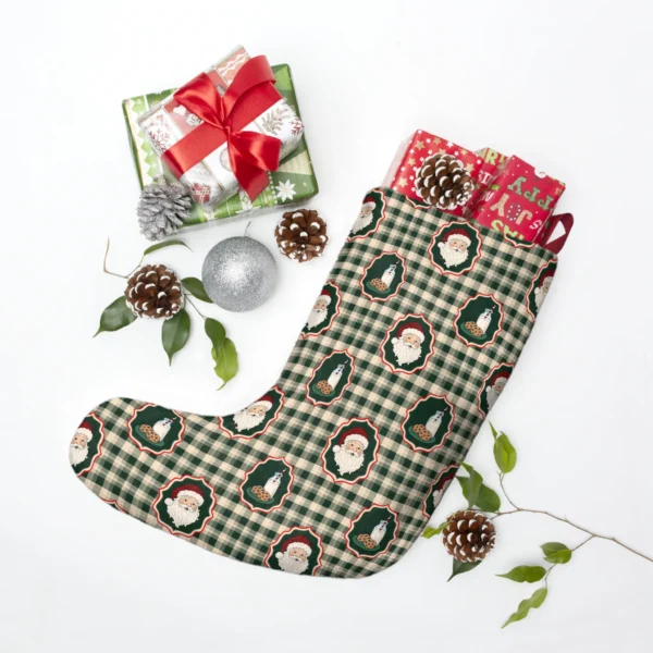 Gingham Santa stocking laid flat beside wrapped presents, pine cones and a silver bauble