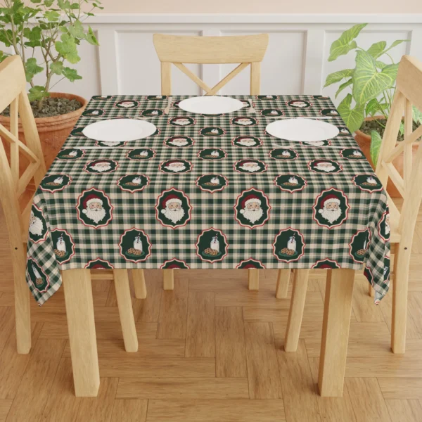 Dining table with white plates on a green and cream check cloth printed with Santas, milk bottles and cookies