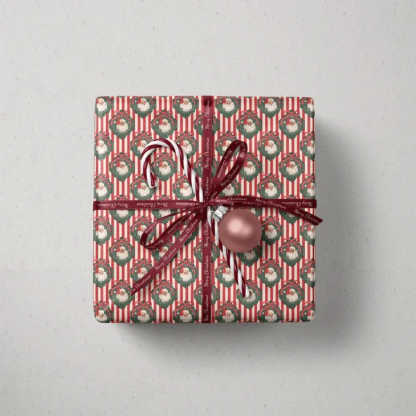 Top view of a gift in vintage Santa red stripe paper with a ribbon, candy canes and a bauble