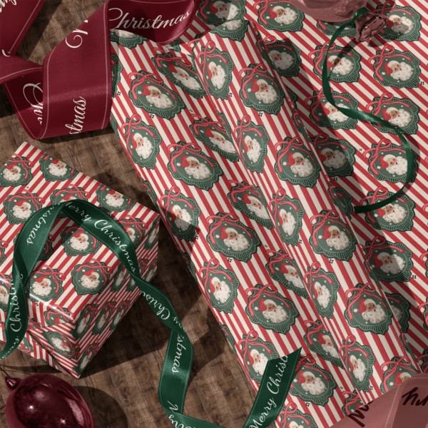 Rolls of vintage Santa red stripe gift wrap and a wrapped box with satin ribbons on a wooden floor
