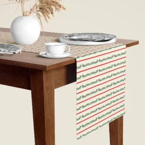 Berry garland stripe Christmas table runner hanging over the end of a walnut dining table, close-up