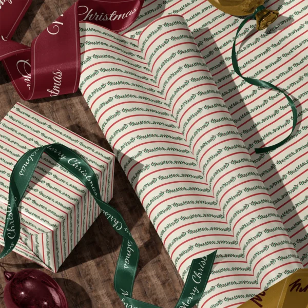 Rolls of berry garland stripe gift wrap and a wrapped box with satin ribbons on a wooden floor