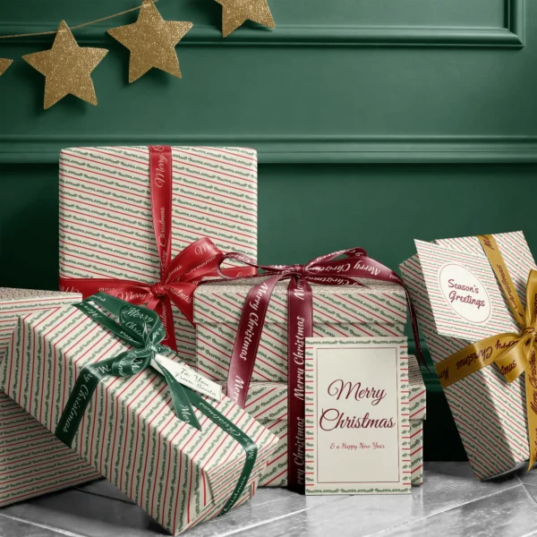 Stack of presents in berry garland stripe paper with ribbons and a Merry Christmas card by a dark green wall