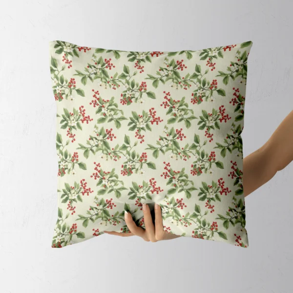 Berry sprig winter pillow held in a hand