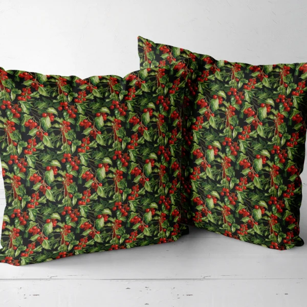 Two black holly berry throw pillows side by side