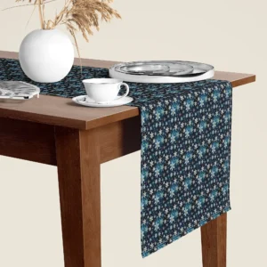 Blue snowflake Christmas table runner hanging over the end of a walnut dining table, close-up