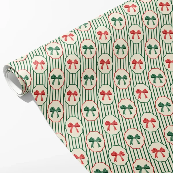 Roll of cream pinstripe wrapping paper with scalloped medallions holding red and green bows, partly unrolled on white