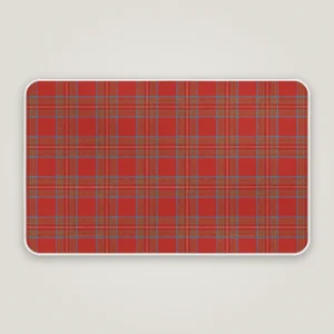 Bright red tartan Christmas bath mat with a white bound edge, seen from above