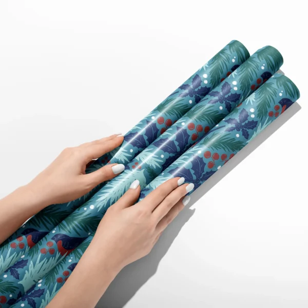 Hands smoothing three rolls of teal bullfinch wrapping paper on a white table