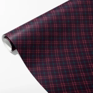 Roll of dark aubergine wrapping paper with rose and teal houndstooth plaid lines, partly unrolled on white