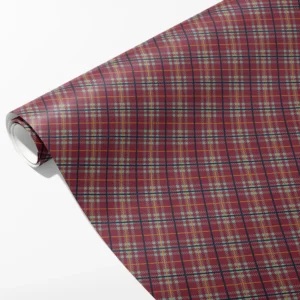 Roll of burgundy wrapping paper with sage green checks, navy lines and mustard stripes, partly unrolled on white
