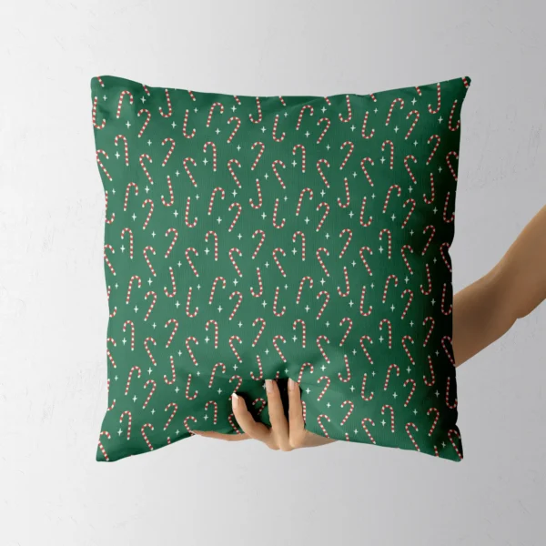 Hand holding the green candy cane throw pillow