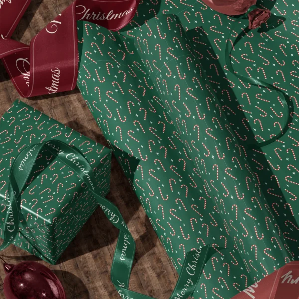 Rolls of candy cane gift wrap and a wrapped box with satin ribbons on a wooden floor