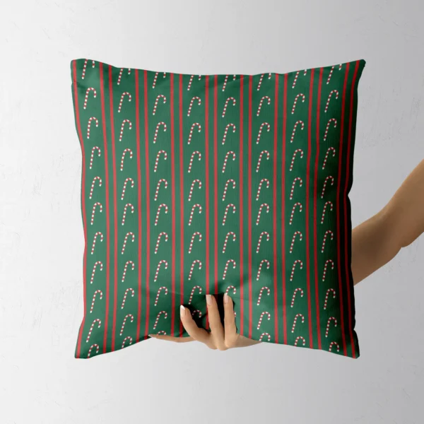 A hand holding the green pinstripe candy cane throw pillow