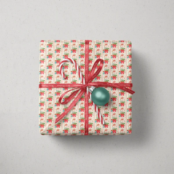 Top view of a gift in red bow bouquet paper with a ribbon, candy canes and a bauble