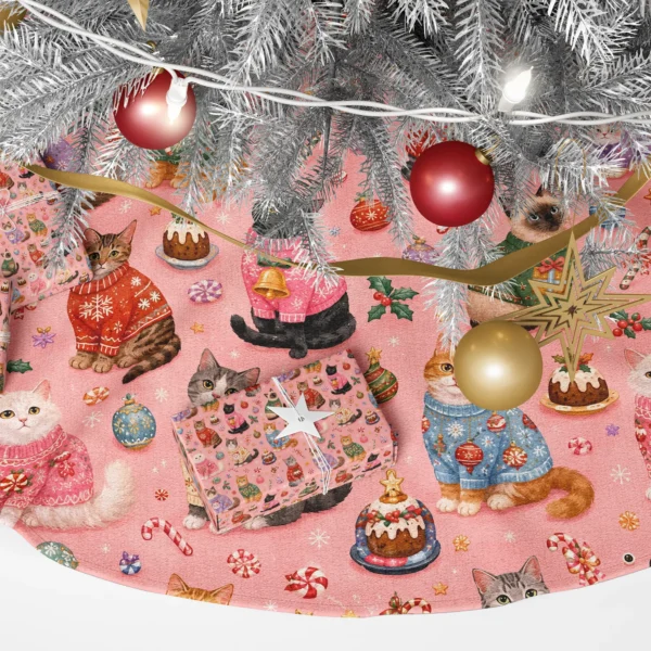 Close-up of a ginger cat, a black cat with a bell and a Siamese in knit sweaters on coral pink