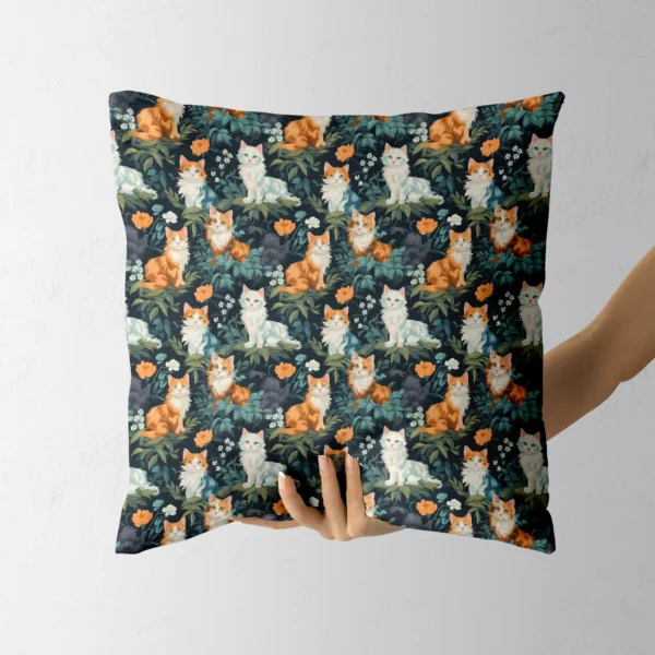 Hand holding a throw pillow with a cats and leaves on forest green print
