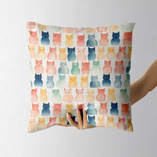 Hand holding a throw pillow with a watercolor cats on cream print