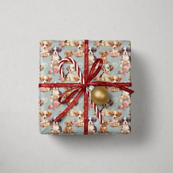 Top view of a gift in dusty blue puppy and rose paper with a red ribbon, a candy cane and a gold bauble