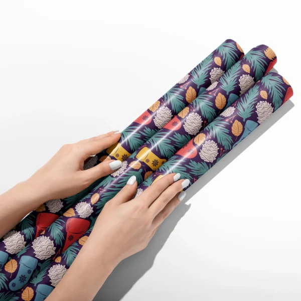 Hands smoothing three rolls of plum stocking wrapping paper on a white table