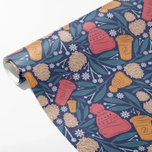 Roll of navy wrapping paper with pink and mustard knit hats, takeaway cups, cones and snowflakes, partly unrolled on white