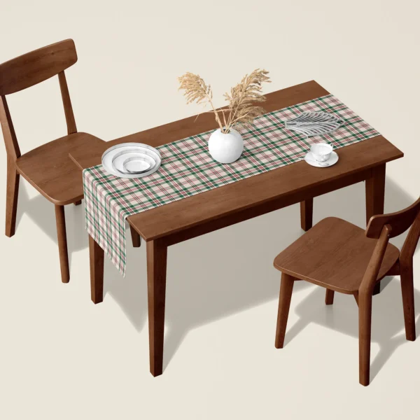 Cream, green and red plaid Christmas table runner on a walnut dining table with two wooden chairs
