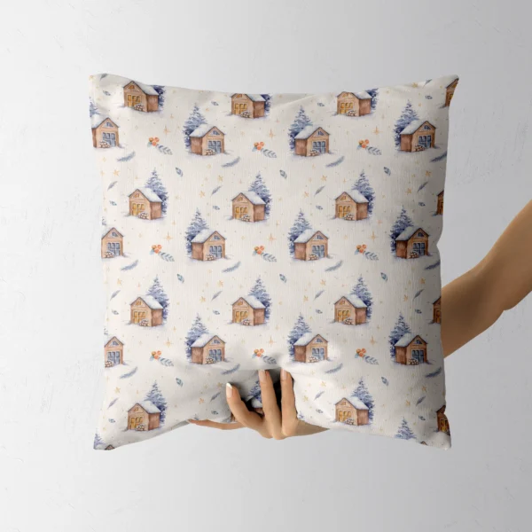 A hand lifting the ivory pillow with watercolor cabins