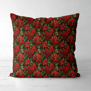 Dark green poinsettia Christmas pillow standing on a white floor, front view