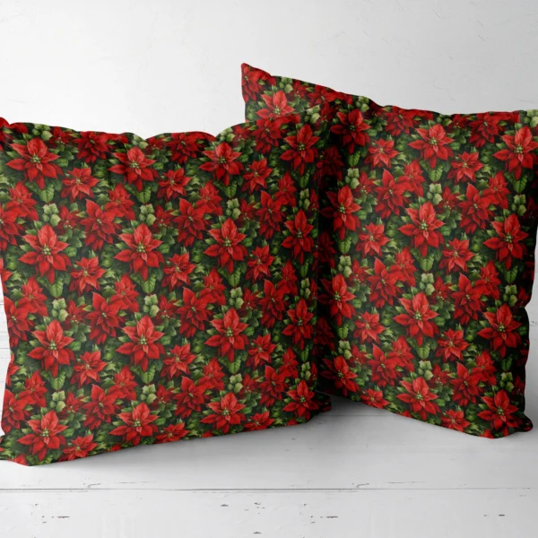 Two dark green poinsettia throw pillows side by side