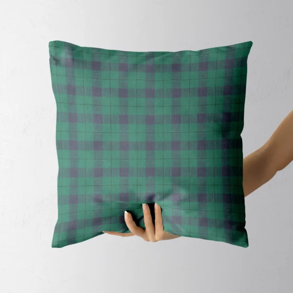 Hand holding the navy and emerald check throw pillow