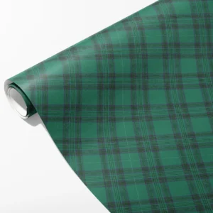 Roll of emerald green tartan wrapping paper with dark green bands and slim plum lines, partly unrolled on white