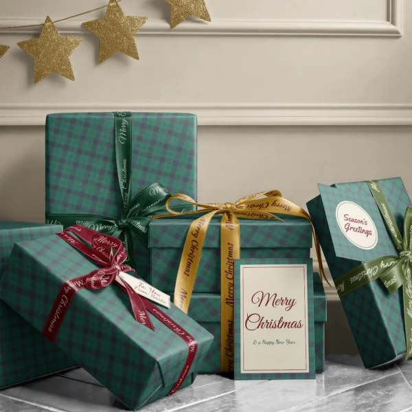 Stack of presents in emerald and navy check paper with ribbons and a Merry Christmas card by a cream wall