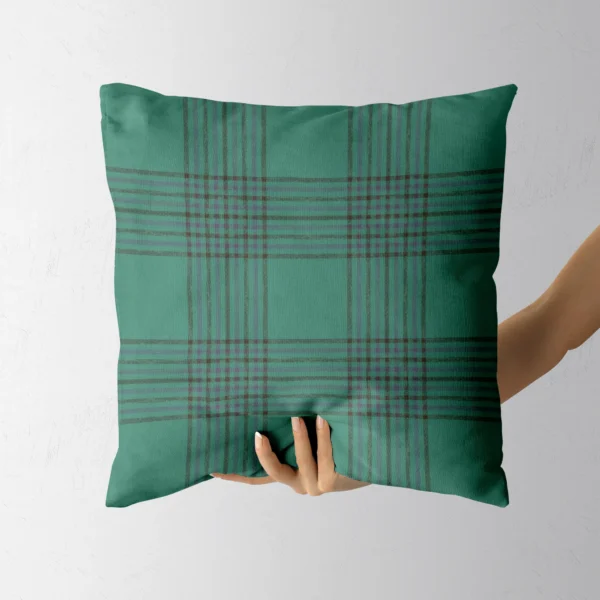 Hand holding the tweed-look emerald throw pillow